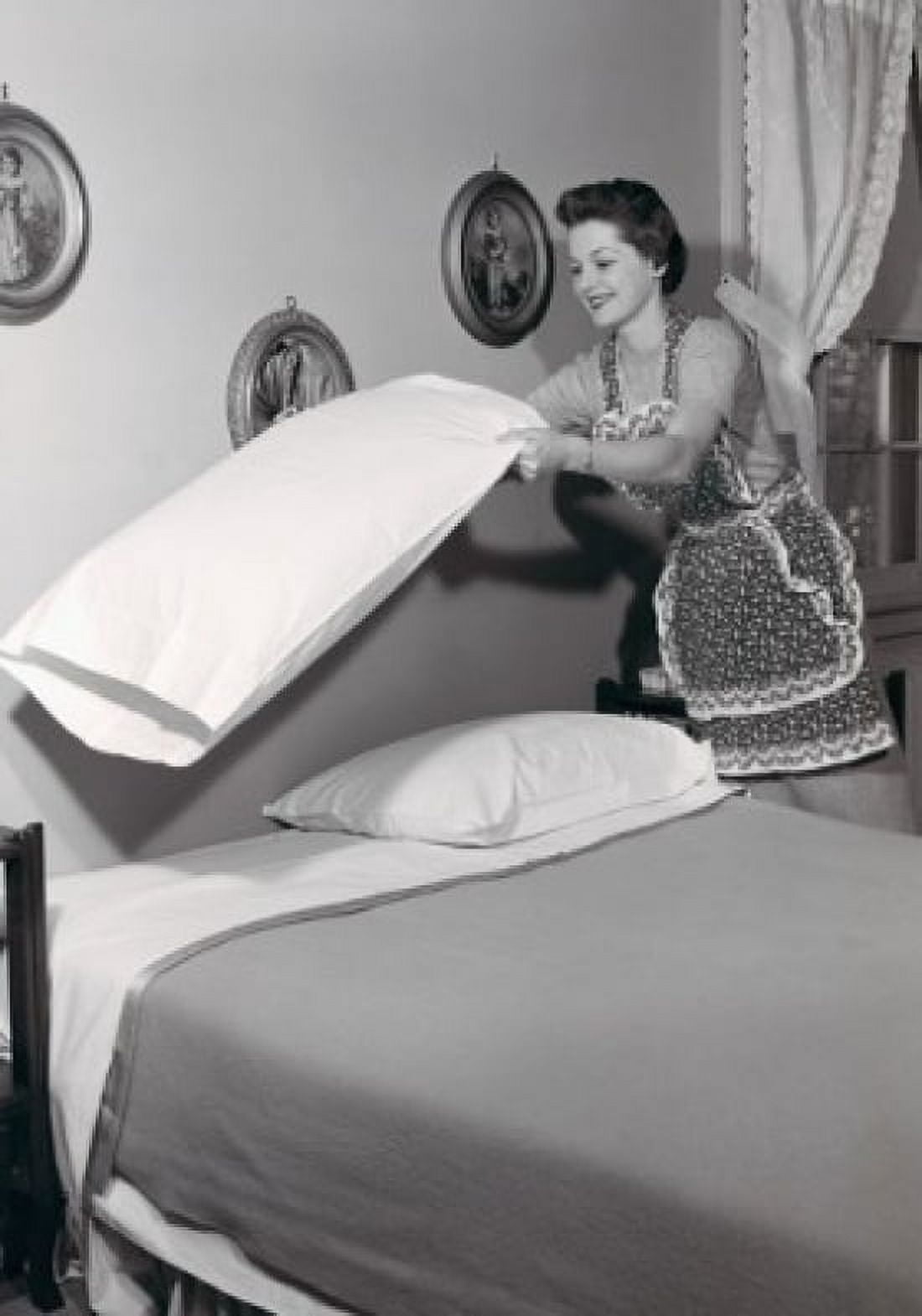 Young woman making bed Canvas Art - (18 x 24)