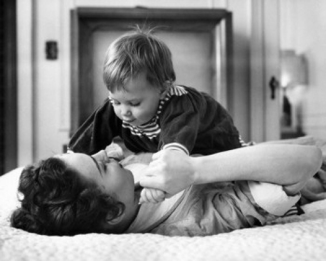 Young woman playing with baby on bed Canvas Art - (18 x 24)