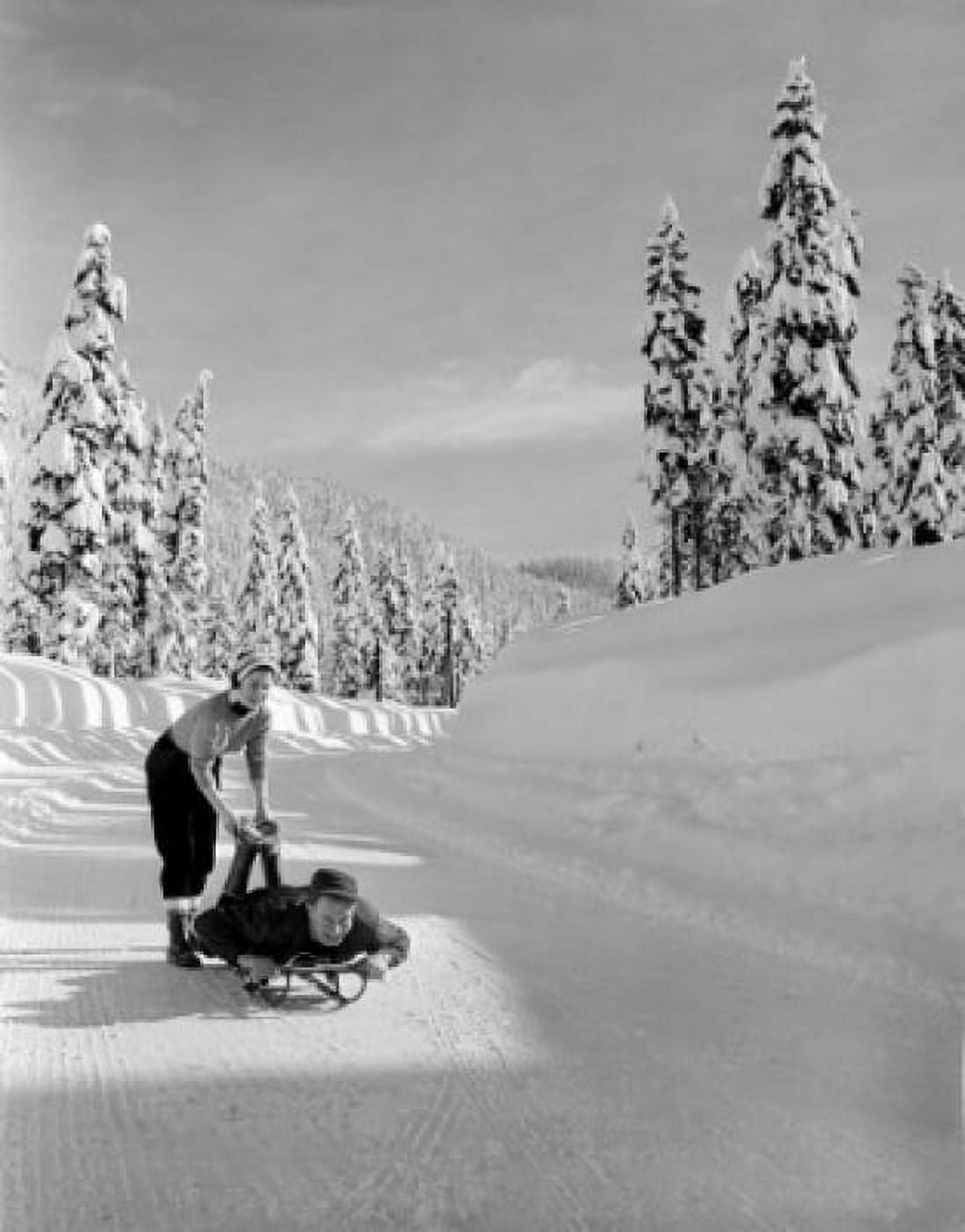 Young woman pushing sledge with young man lying on it Canvas Art - (18 x 24)