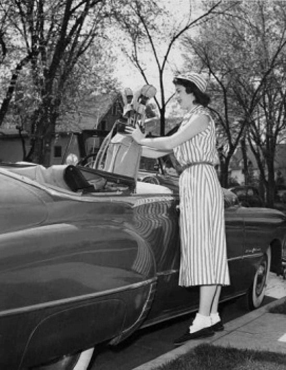 Young woman putting a golf bag in a car Canvas Art - (24 x 36)