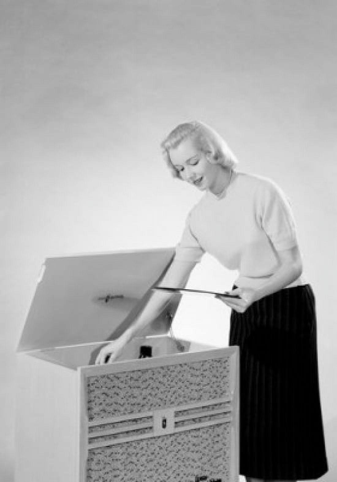 Young woman putting vinyl record to record player Canvas Art - (18 x 24)