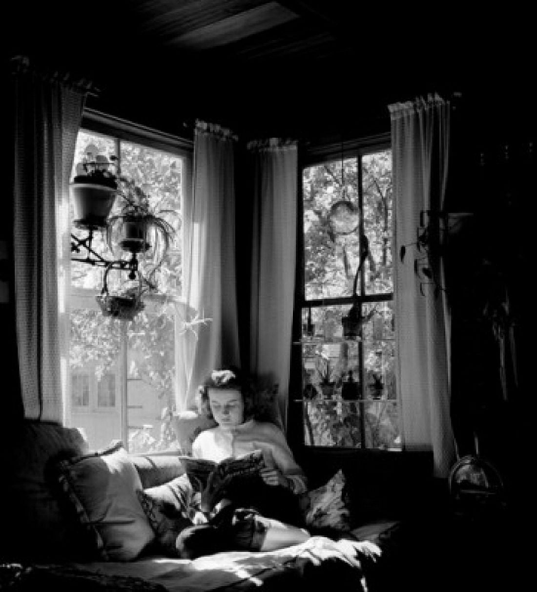 Young woman reading in living room Canvas Art - (18 x 24)