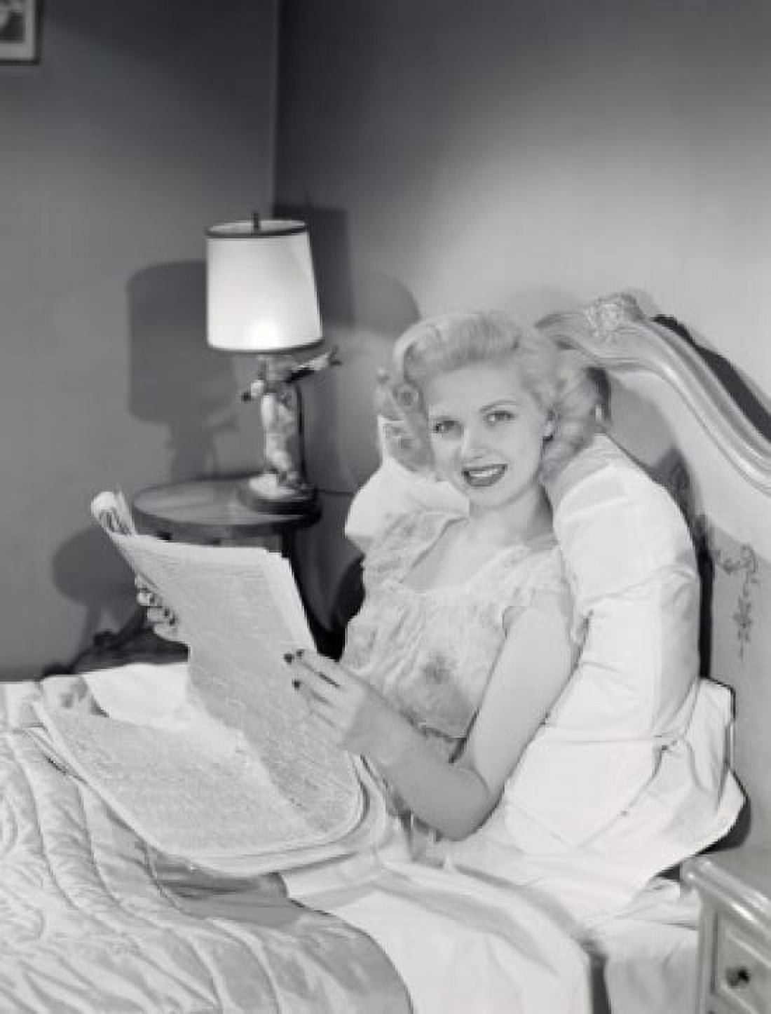 Young woman reading newspaper in bed Canvas Art - (18 x 24)