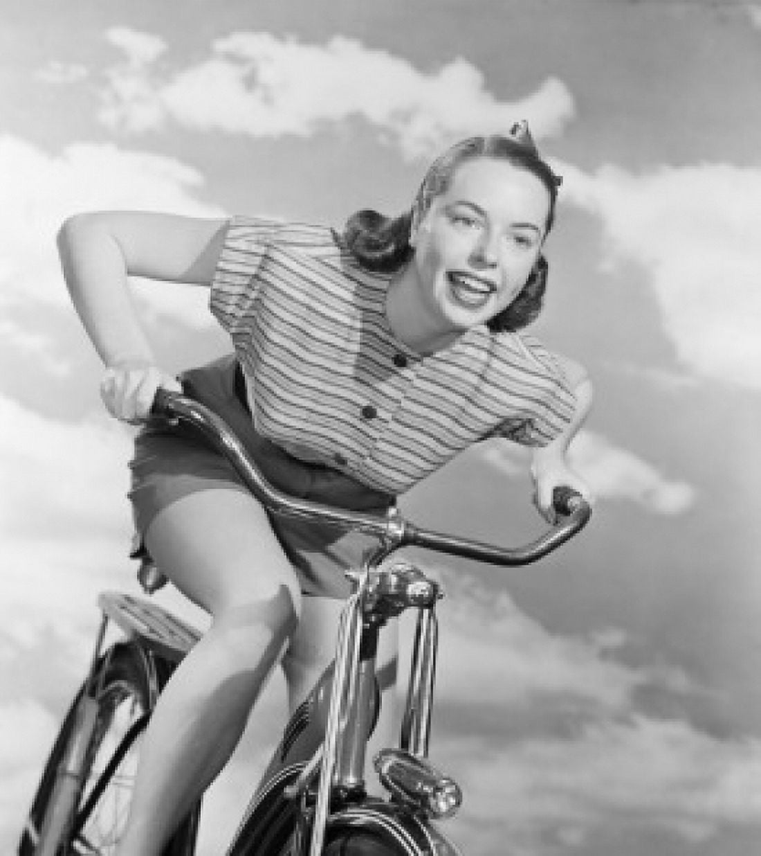 Young woman riding bicycle against cloudy sky Canvas Art - (18 x 24)