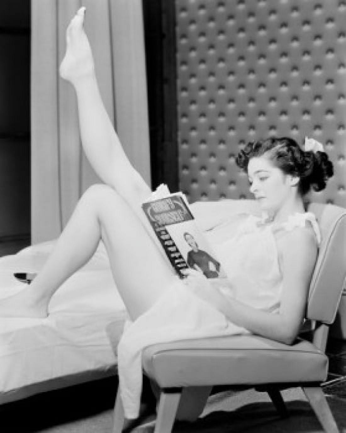 Young woman sitting and reading magazine Canvas Art - (18 x 24)