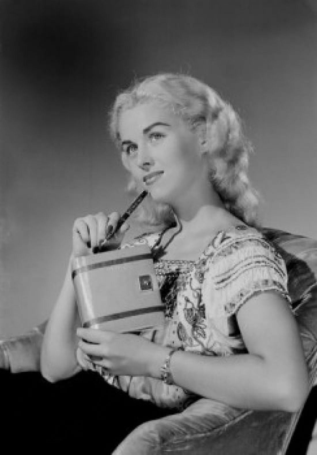 Young woman sitting in chair and holding personal organizer Canvas Art - (18 x 24)