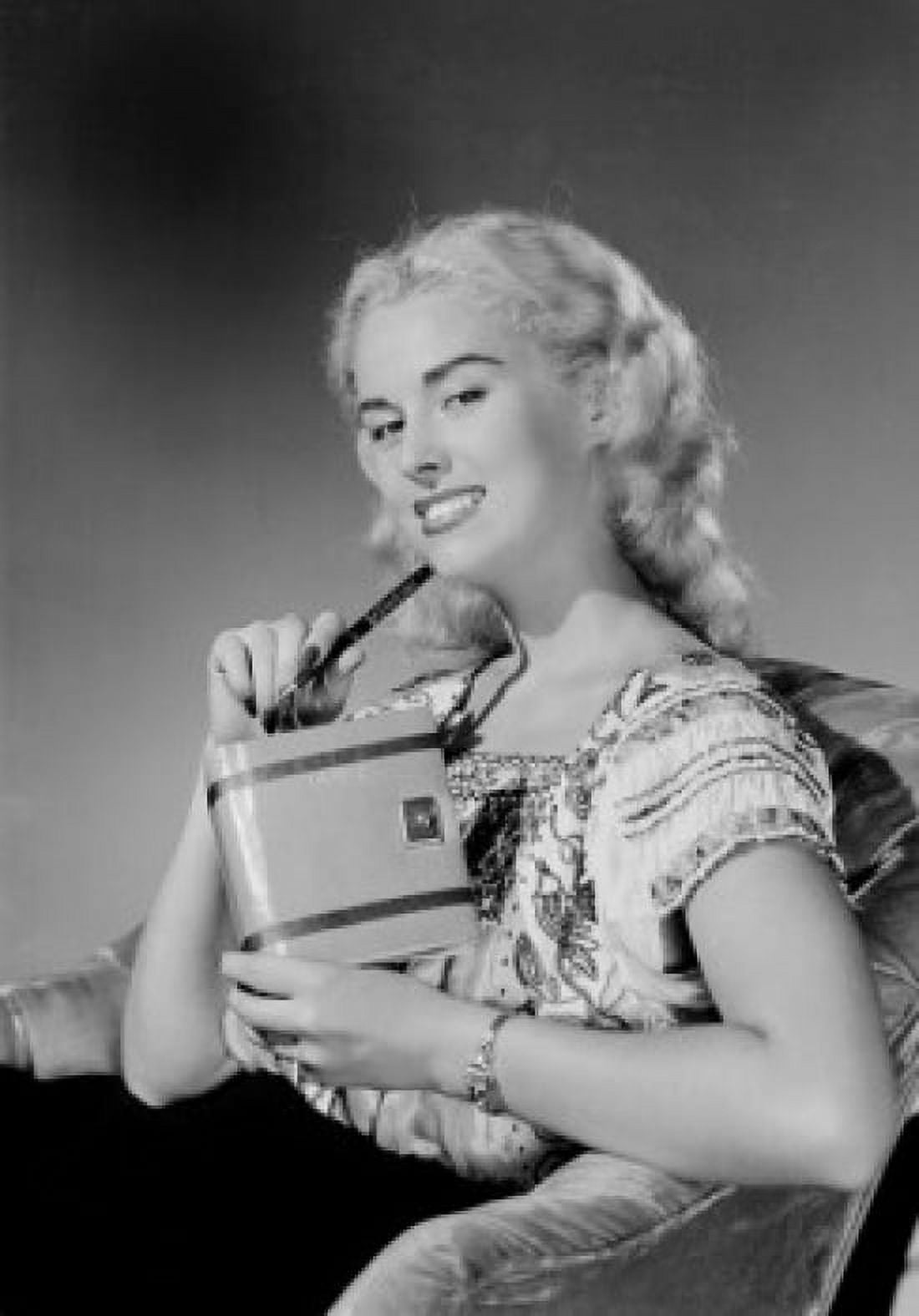 Young woman sitting in chair and holding personal organizer Canvas Art - (24 x 36)