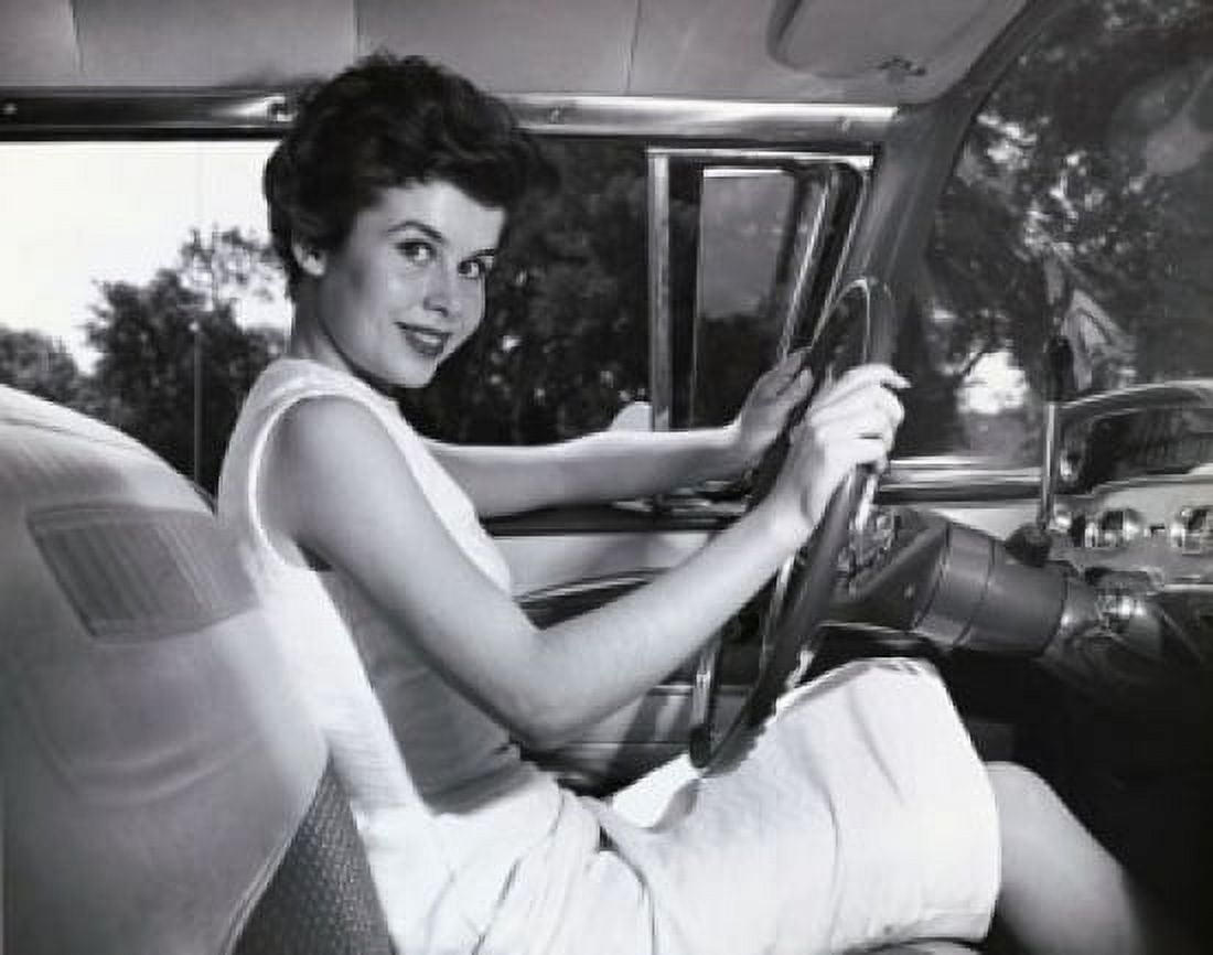 Young woman sitting in the drivers seat of a car and smiling Canvas Art - (24 x 36)