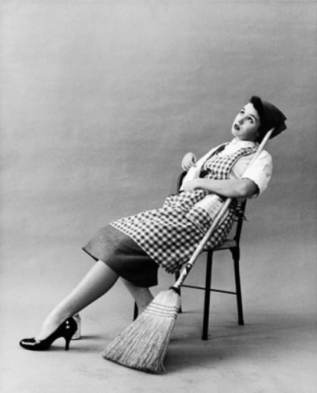 Young woman sitting on a chair holding a broom stick Canvas Art - (18 x 24)