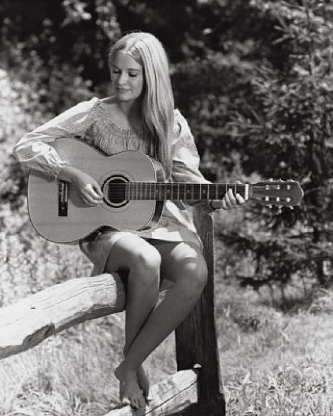 Young woman sitting on a fence and playing the guitar Canvas Art - (24 x 36)