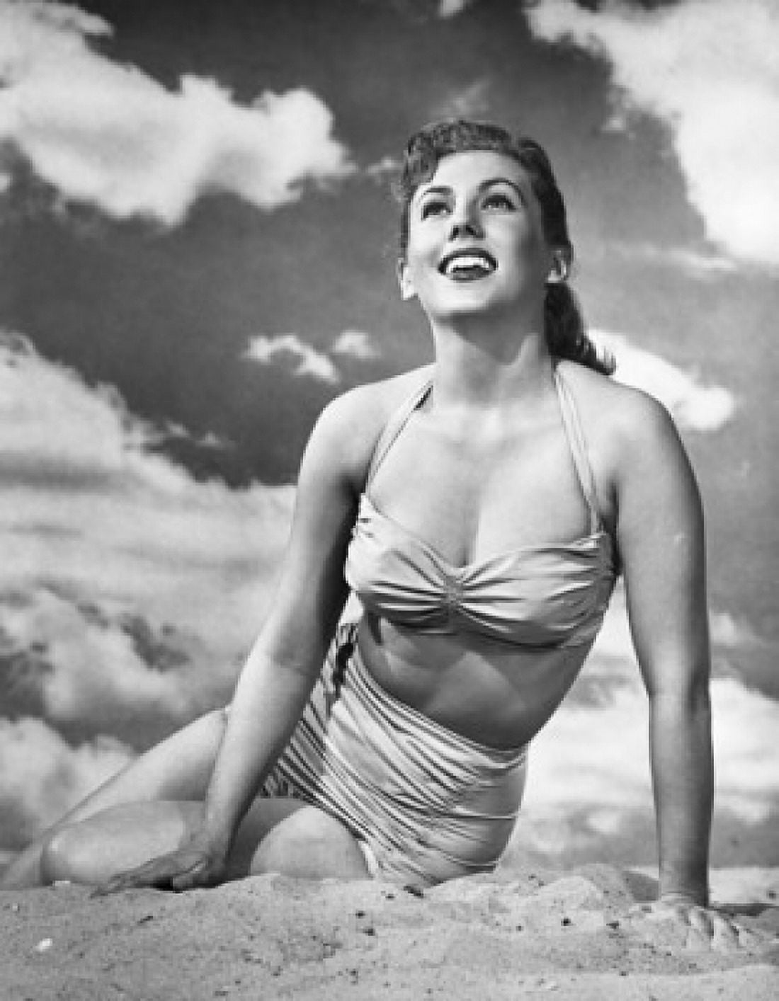 Young woman sitting on the beach and smiling Canvas Art - (18 x 24)