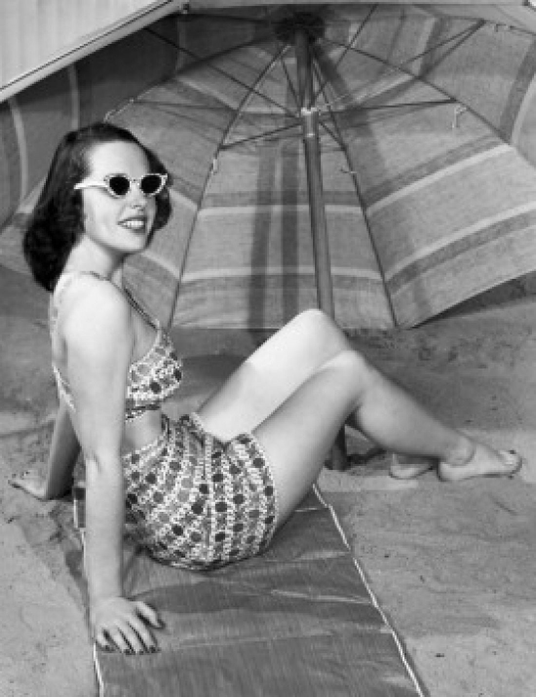Young woman sitting under beach umbrella Canvas Art - (18 x 24)