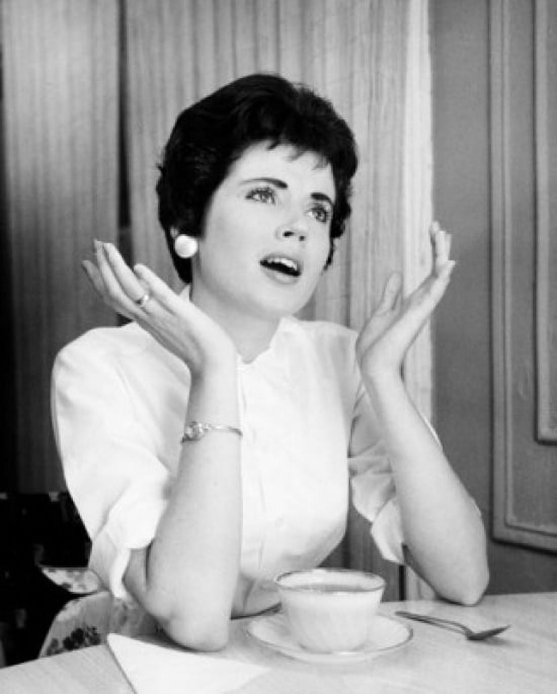 Young woman sitting with a tea cup gesturing Canvas Art - (18 x 24)