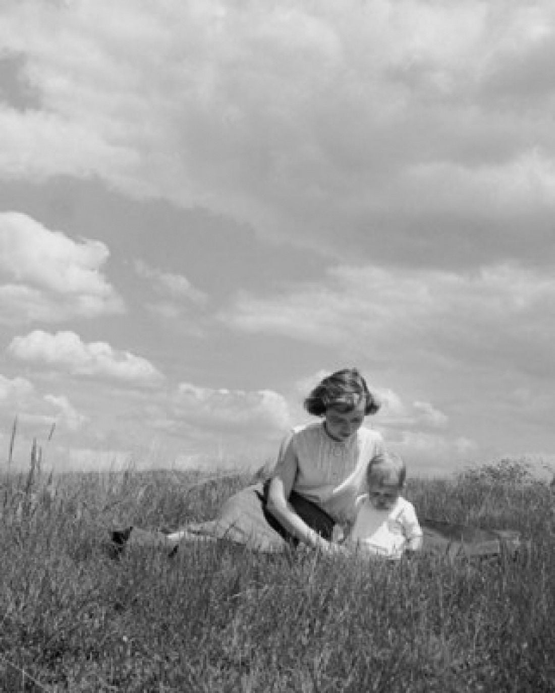 Young woman sitting with her baby in a field Canvas Art - (24 x 36)