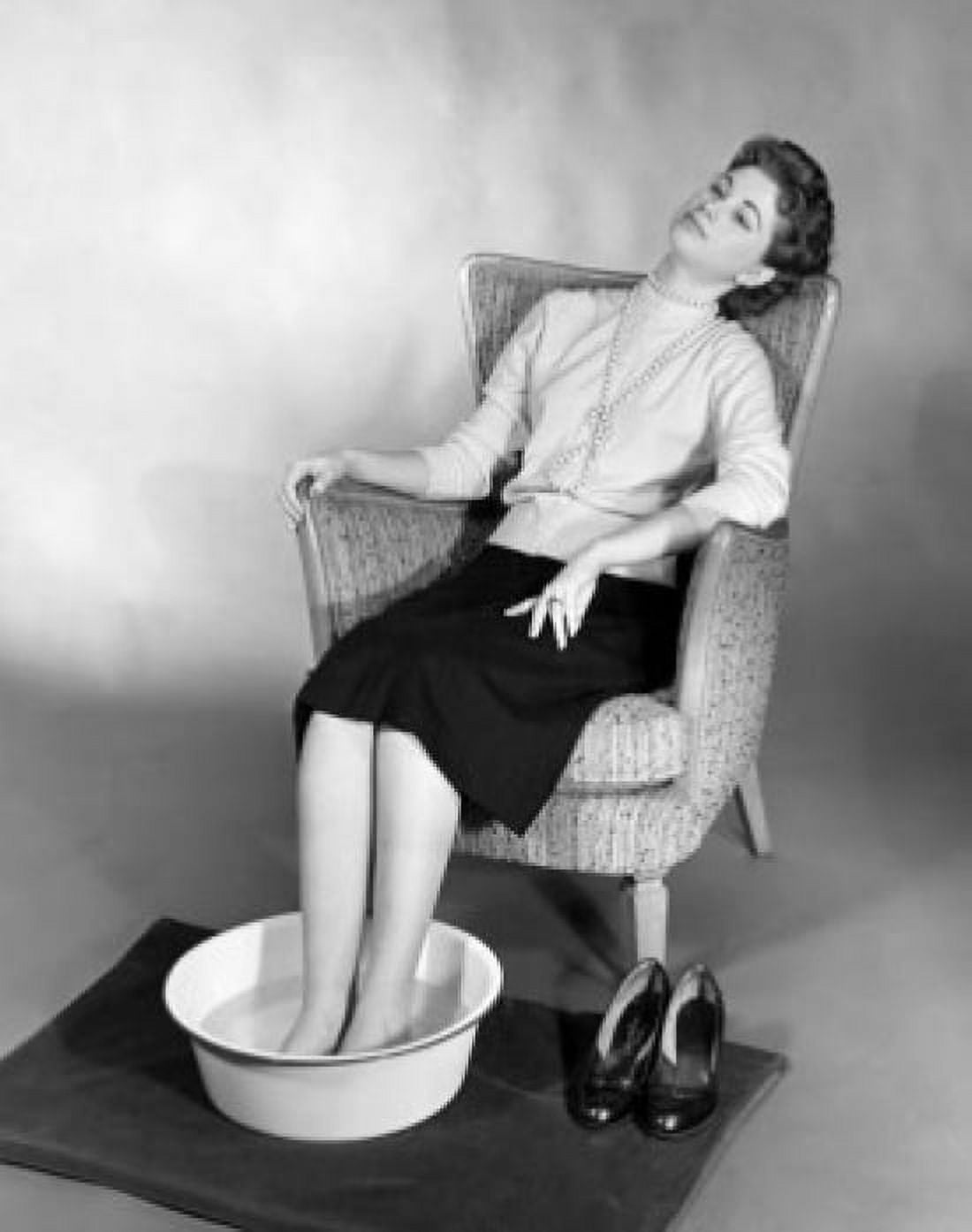 Young woman sitting with her feet soaked in a basin of water Canvas Art - (18 x 24)