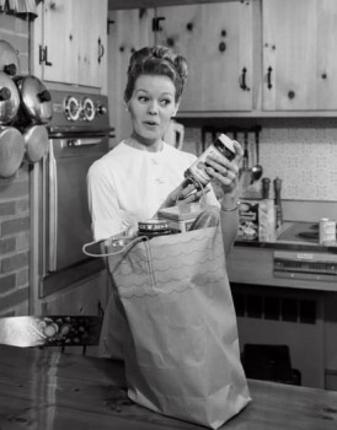 Young woman standing in a kitchen holding a jar Canvas Art - (24 x 36)