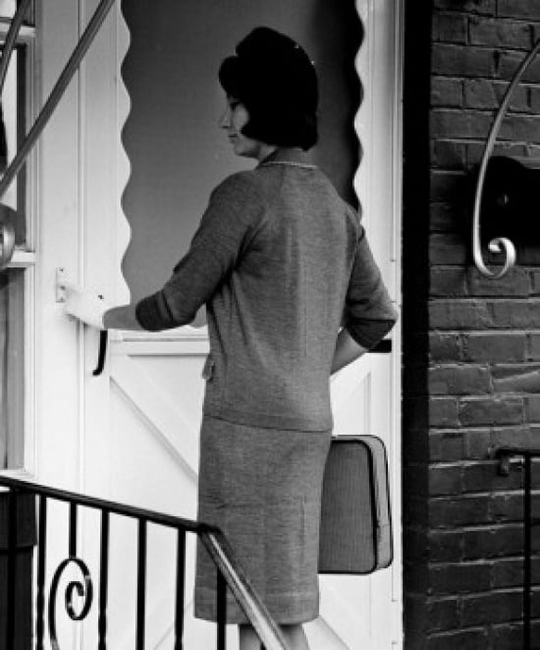Young woman standing in front of entrance door using doorbell Canvas Art - (24 x 36)