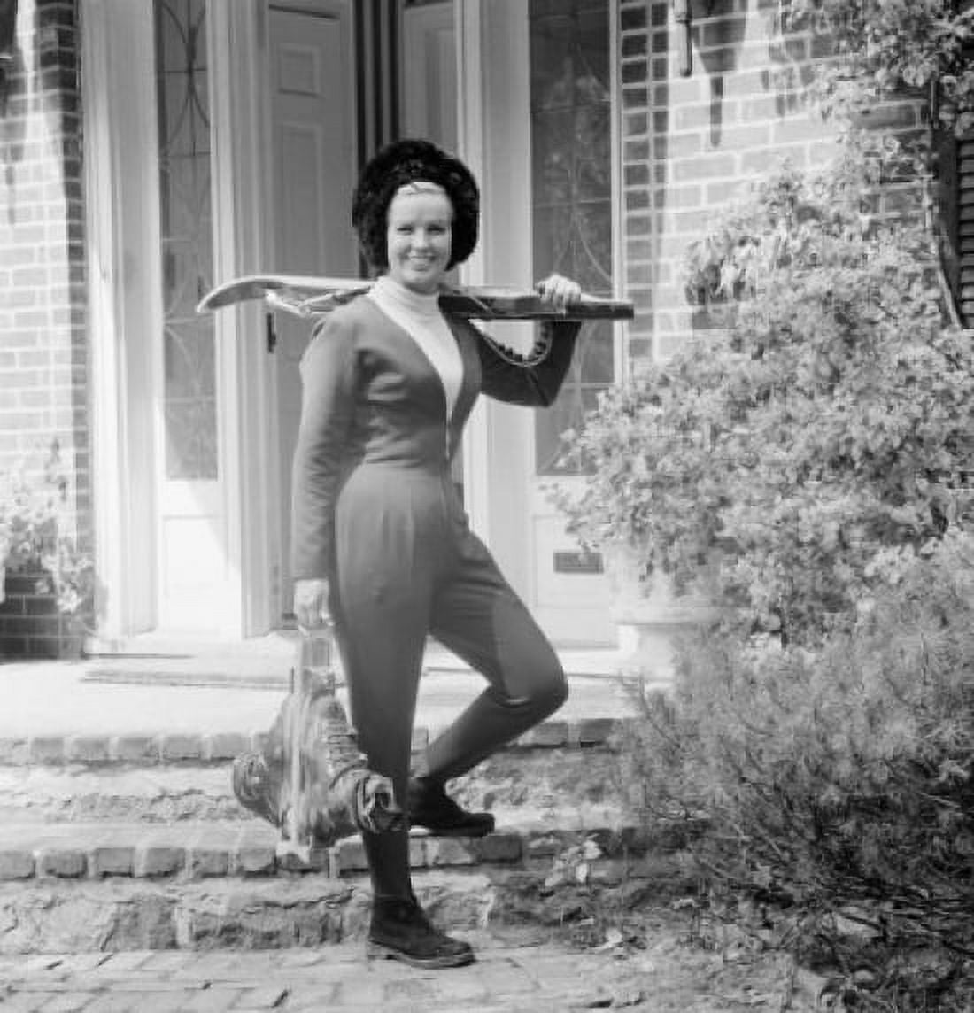 Young woman standing in front of house holding crossbow Canvas Art - (18 x 24)