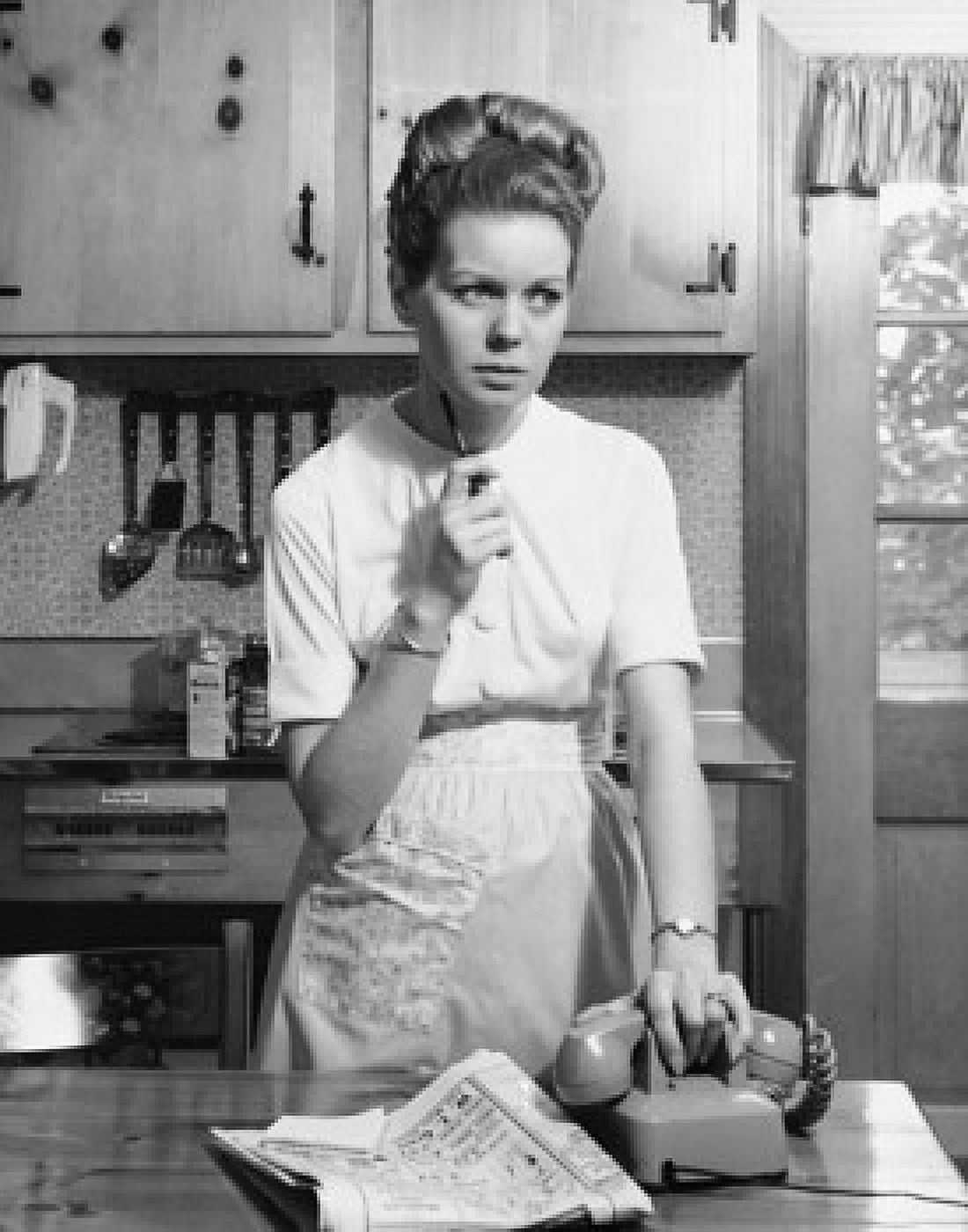 Young woman standing in kitchen holding phone Canvas Art - (18 x 24)