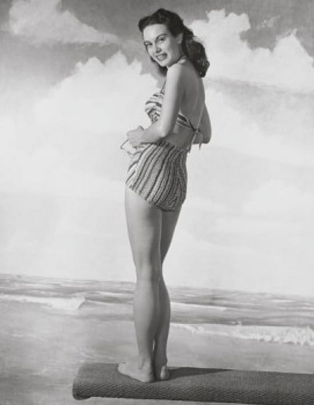 Young woman standing on a beach mat and smiling Canvas Art - (24 x 36)
