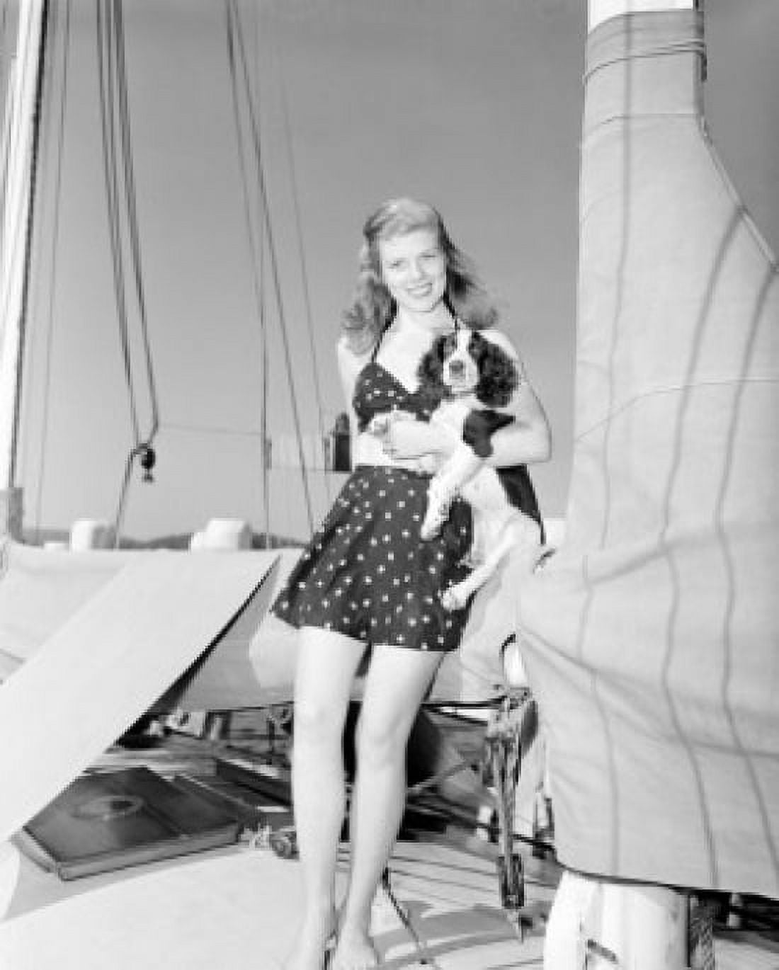 Young woman standing on boat and holding dog Canvas Art - (24 x 36)