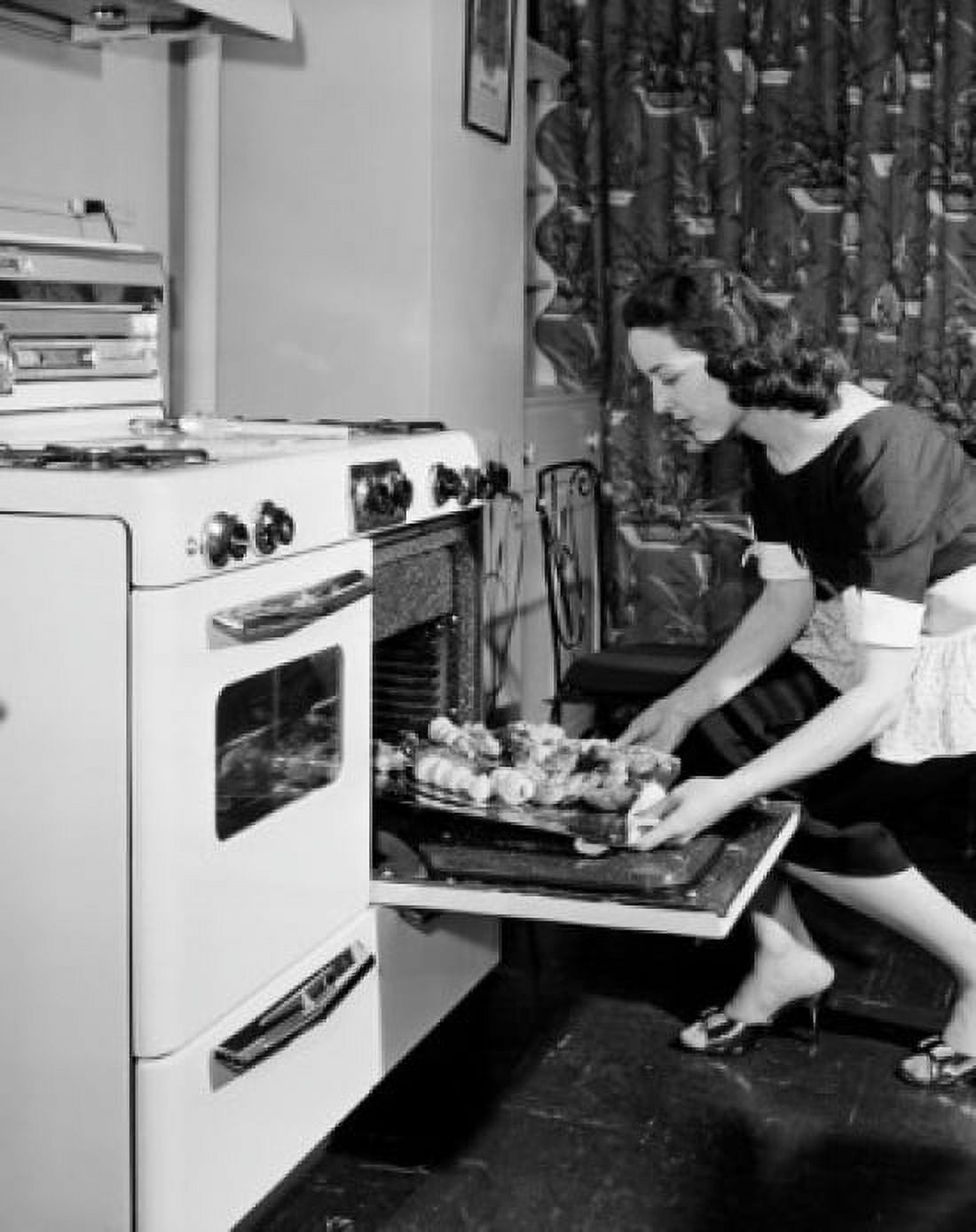 Young woman taking baked food out of oven Canvas Art - (24 x 36)