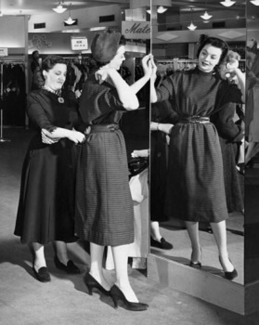 Young woman trying on clothes in a clothing store and a mid adult woman helping her Canvas Art - (24 x 36)