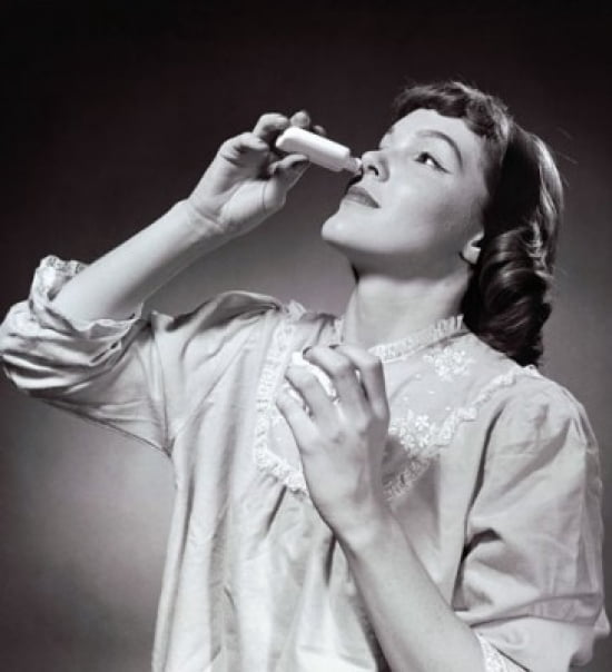 Young woman using nasal spray Canvas Art - (18 x 24)