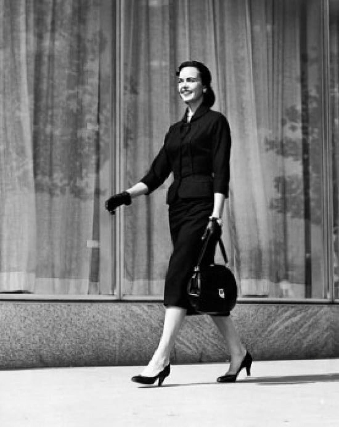 Young woman walking on a sidewalk holding a hand bag Canvas Art - (24 x 36)