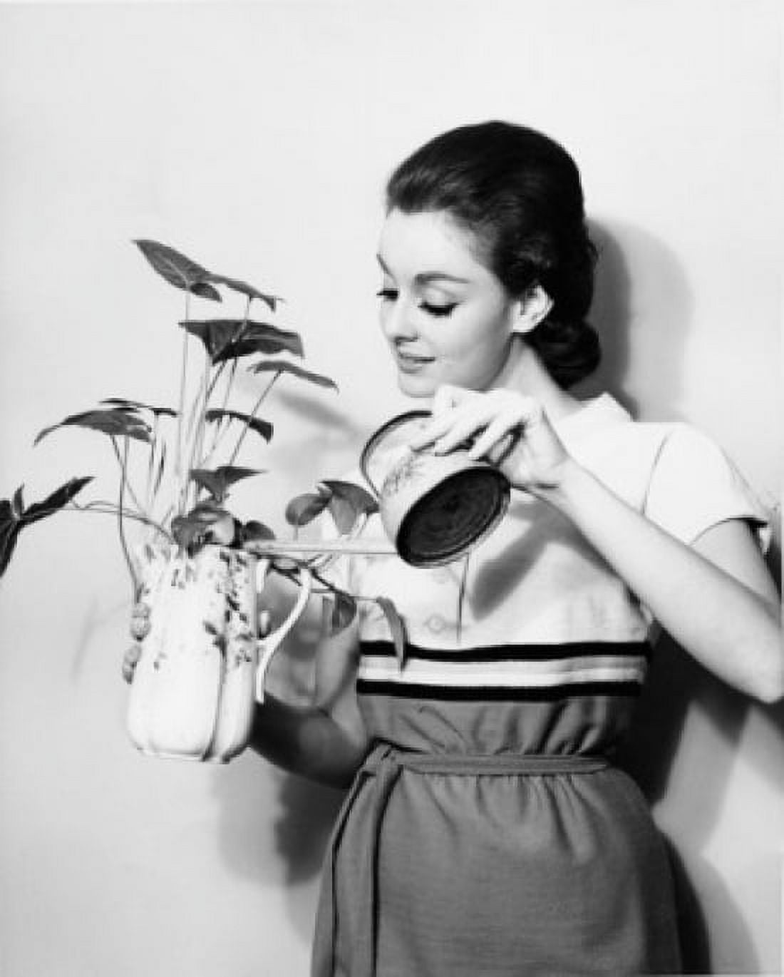 Young woman watering plant Canvas Art - (24 x 36)