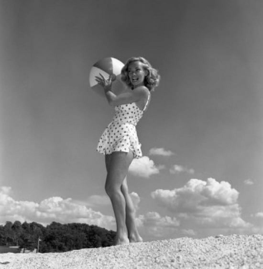 Young woman wearing swimsuit standing on beach and holding beach ball Canvas Art - (24 x 36)