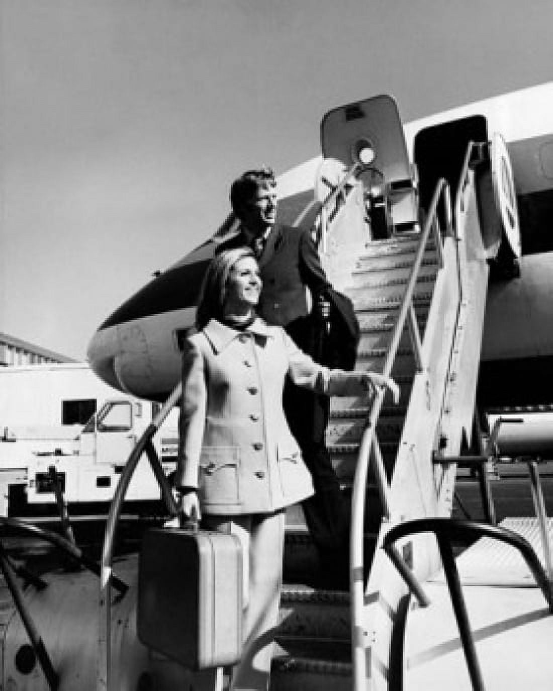 Young woman with a young man standing on a staircase of an airplane Canvas Art - (24 x 36)