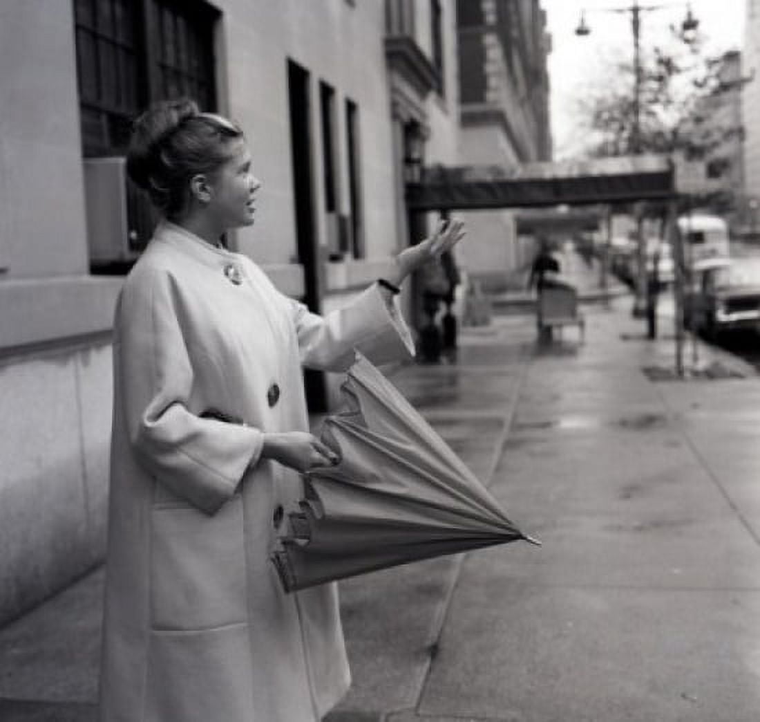 Young woman with folded umbrella checking if raining Canvas Art - (24 x 36)