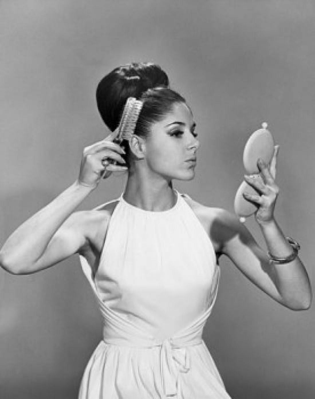 Young woman with hairbun brushing her hair Canvas Art - (24 x 36)