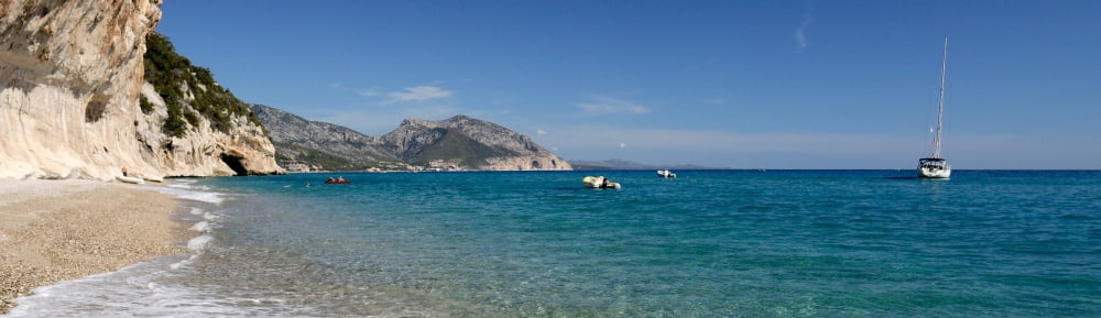 Zodiacs and sailboat in the sea Cala Luna Cala Gonone Nuoro Sardinia Italy Canvas Art - Panoramic Images (36 x 12)