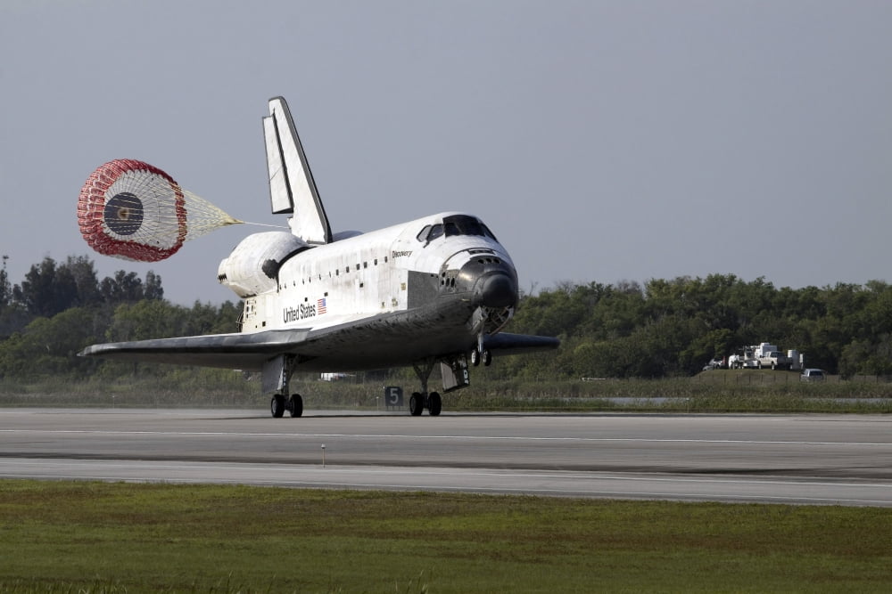 With drag chute unfurled space shuttle Discovery lands on Runway 33 at the Shuttle Landing Facility at Kennedy Space Center in Florida Canvas Art - Stocktrek Images (34 x 23)
