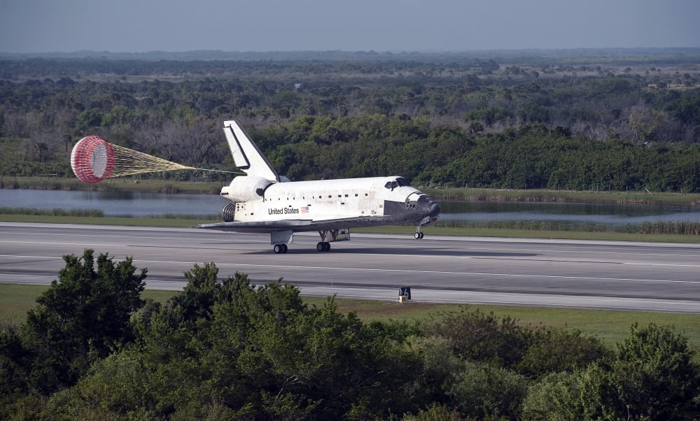 With drag chute unfurled space shuttle Discovery lands on Runway 33 at the Shuttle Landing Facility at Kennedy Space Center in Florida Canvas Art - Stocktrek Images (37 x 22)