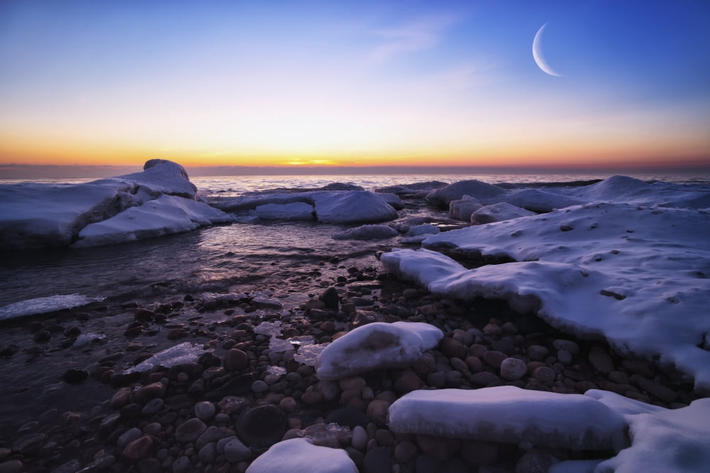 On the icy shores of Lake Michigan the moon (double exposed) and ice creates a beautiful morning Wisconsin United States of America Canvas Art - Markos Berndt Design Pics (19 x 12)