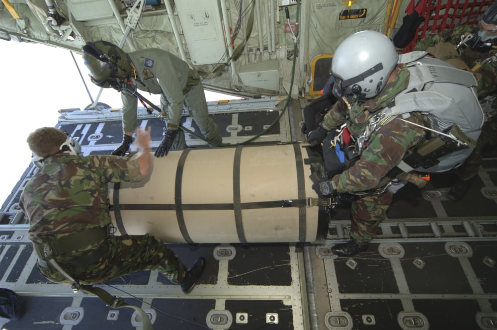 A member from the Pathfinder Platoon gets ready to jump from a C-130 transport plane with a container Canvas Art - Andrew ChittockStocktrek Images (34 x 23)