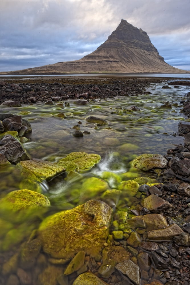 The mountain Kirkjufell rises above the ocean near town of Grundarfjorour Snaefellsnes Peninsula Iceland Canvas Art - Robert Postma Design Pics (11 x 17)