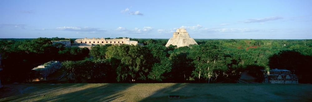 A panoramic view from left to right Nunnery Quadrangle and the Pyramid of the Magician Mayan ruin of Uxmal at sunset in the Yucatan Peninsula Mexico Canvas Art - Panoramic Images (27 x 9)