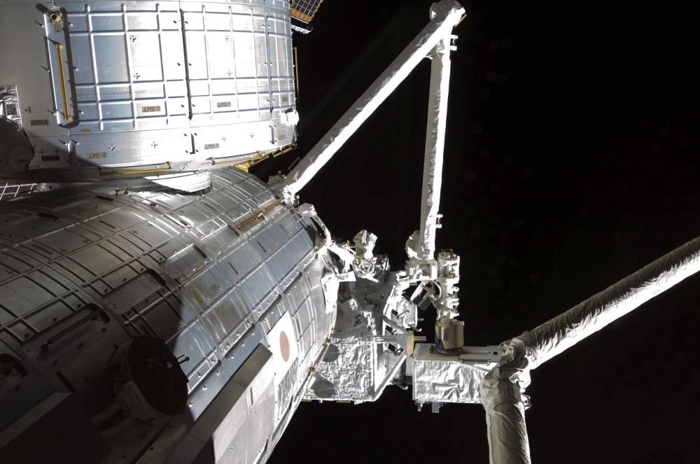 The robotic arm of the Japanese Experiment Module assists in installing components on the Japanese Exposed Facility Canvas Art - Stocktrek Images (34 x 23)