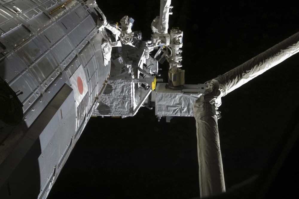 The robotic arm of the Japanese Experiment Module assists in installing components on the Japanese Exposed Facility Canvas Art - Stocktrek Images (34 x 23)