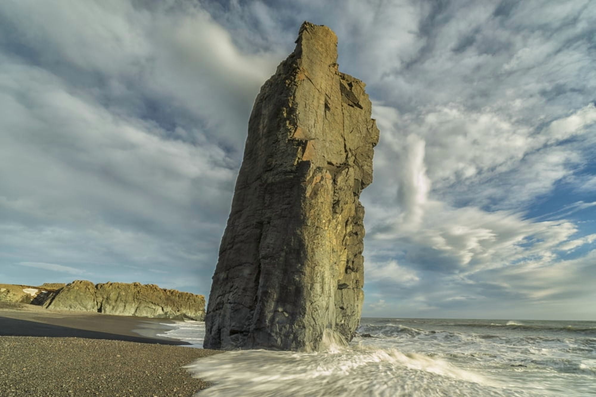 A sea stack rises out of the bedrock while waves crash against it along the beaches of the East Fjords Iceland Canvas Art - Robert Postma Design Pics (19 x 12)