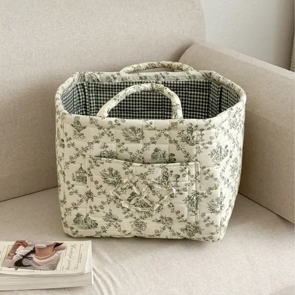 This storage basket features a floral pattern and quilted fabric. It can store clothes, blankets, and other items. Machine washable, it has a large capacity, a woven design, and is ideal for organizi