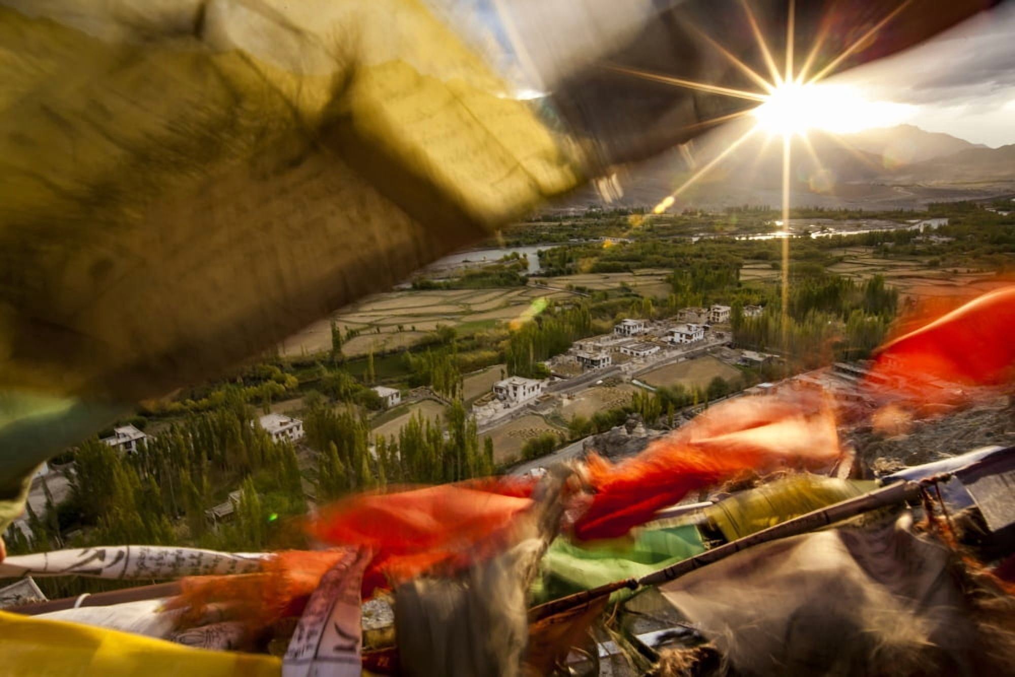 The sun sets over a Ladakhi village outside of Leh viewed through the flapping prayer flags Ladakh India Canvas Art - Matt Brandon Design Pics (19 x 12)