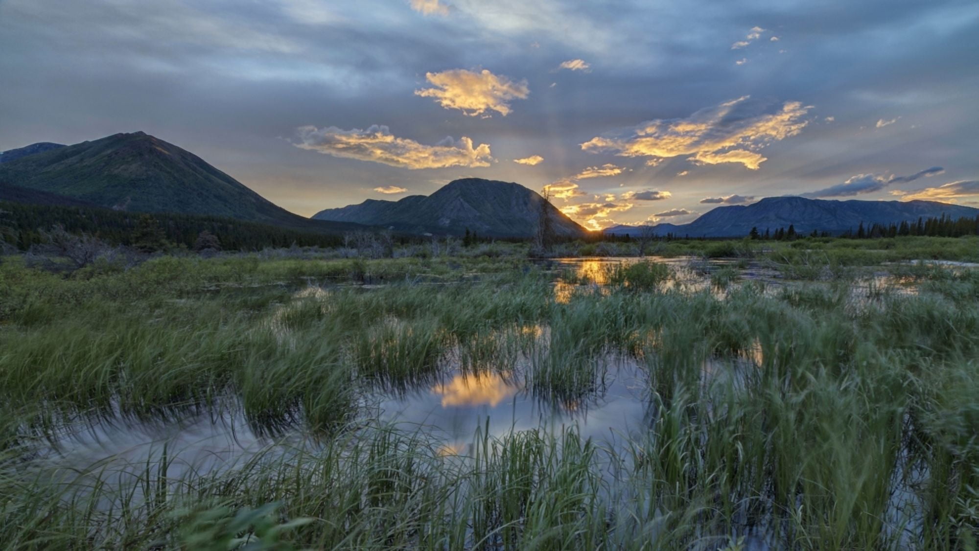 The sun sets and creates bands of light behind Toad Mountain near Annie Lake Whitehorse Yukon Canada Canvas Art - Robert Postma Design Pics (20 x 11)
