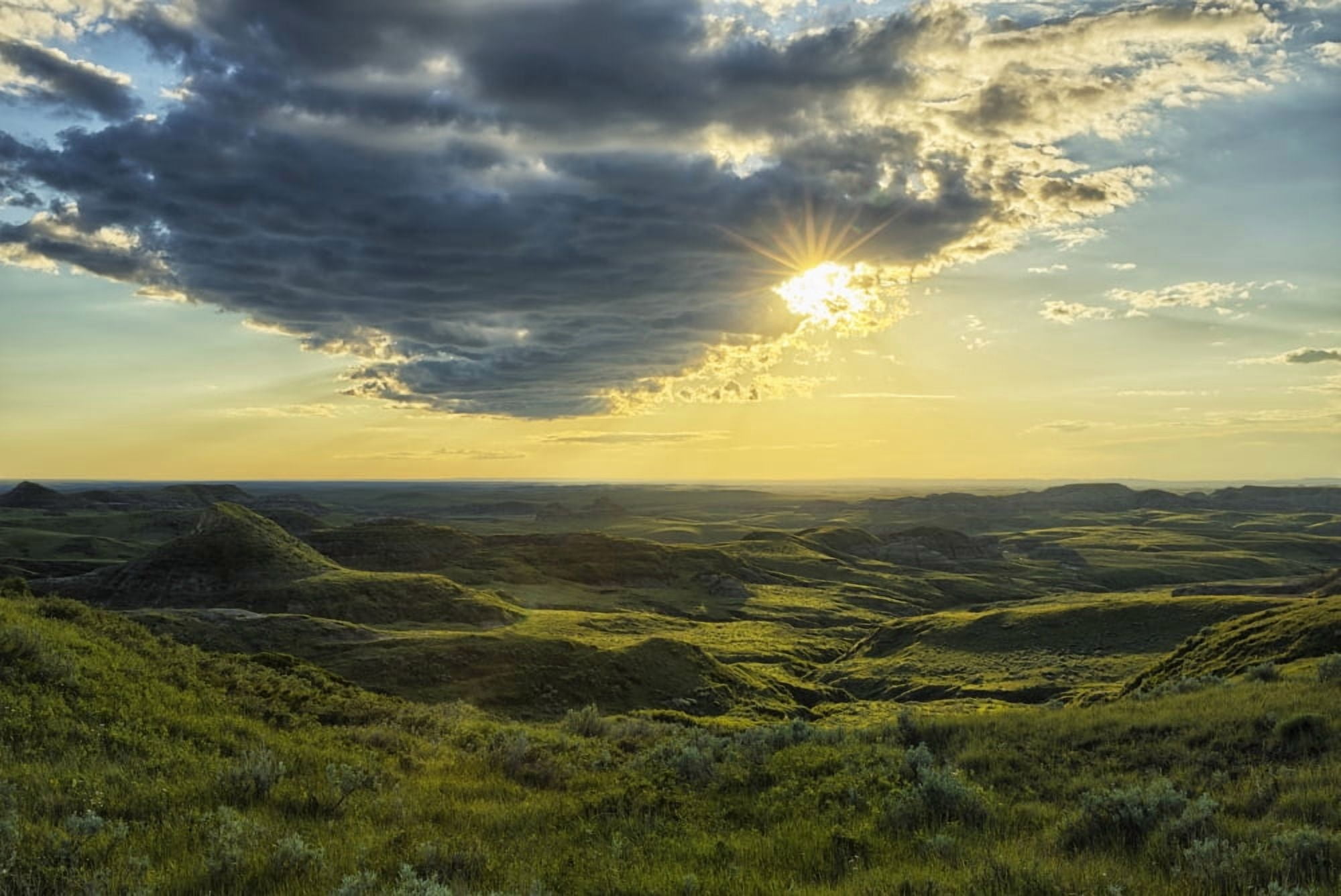 The sun shines through a cloud over the Killdeer Badlands Grasslands National Park Saskatchewan Canada Canvas Art - Robert Postma Design Pics (38 x 24)
