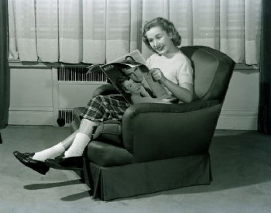 young woman sitting in armchair reading magazine Canvas Art - (18 x 24)
